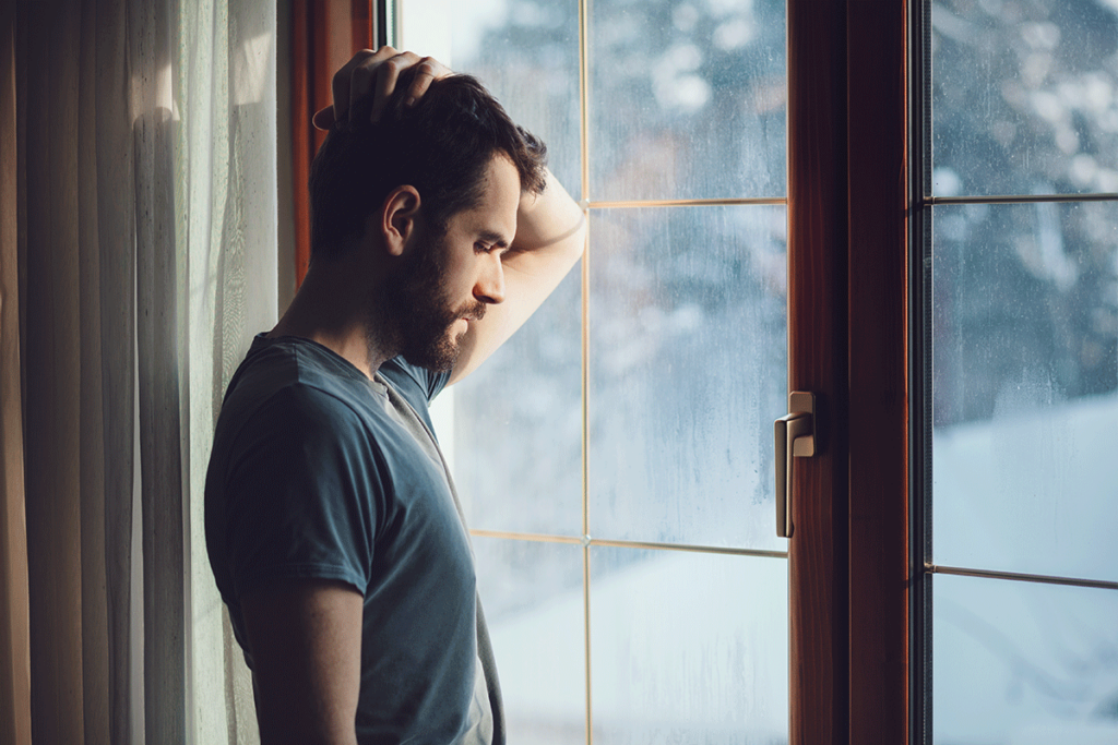 a man leans on the window looking out and wondering are benzos addictive