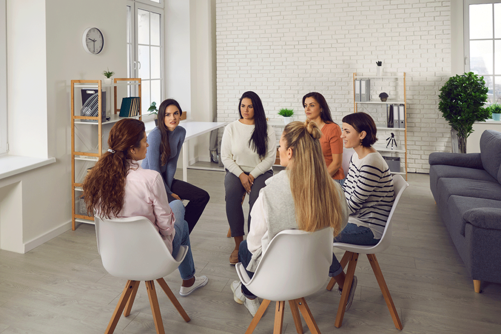 a group of women sit in group therapy in their women's rehab program in houston tx